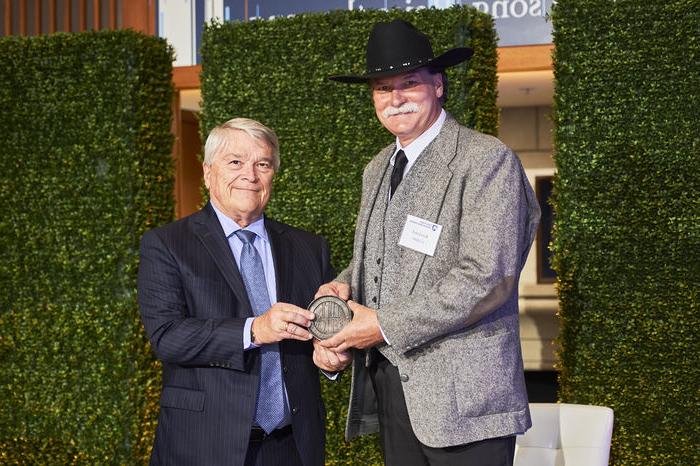 Rawland Cogan accepts his Alumni Fellow award from Penn State President Eric Barron.  